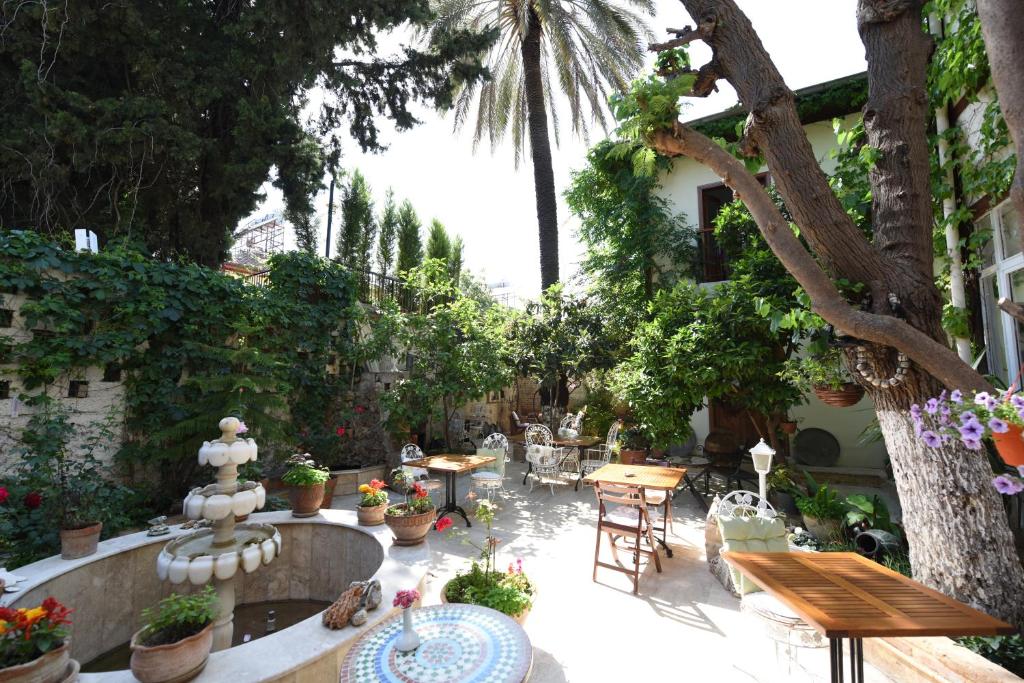 un jardín con mesas, sillas y un árbol en Sibel Hotel en Antalya