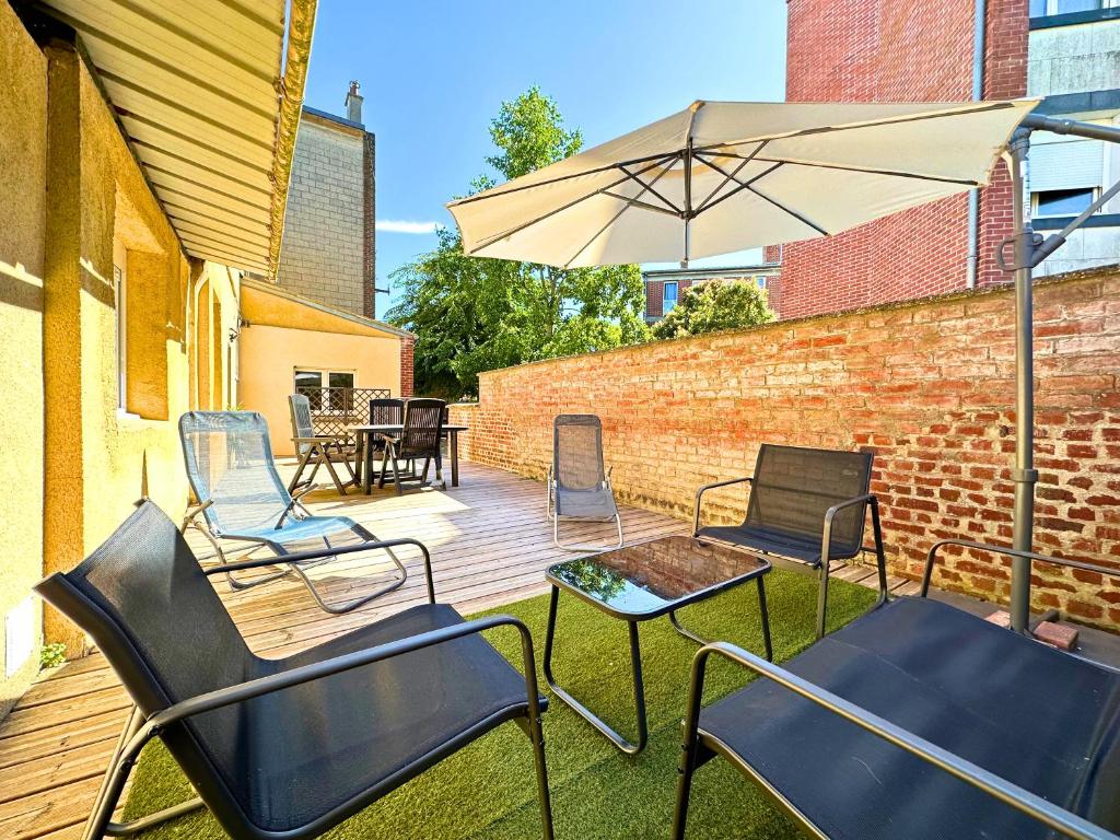 a wooden deck with chairs and an umbrella at Chill & Sun - Terrasse extérieure - Parking - Wifi - 4p in Amiens