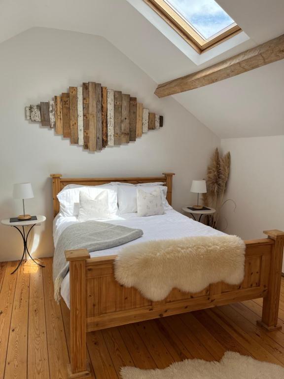 赫里福德的住宿－The Hayloft，一间卧室配有一张带白色床单和枕头的木制床。