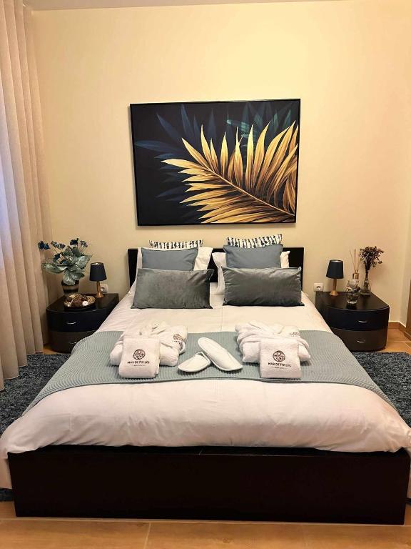 a bedroom with a large bed with towels on it at Mar de Fulles in Buarcos