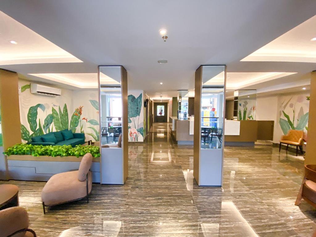 美娜多的住宿－Lun Hotel Manado，大堂设有玻璃门,中间设有沙发