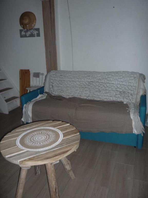un petit lit avec un tabouret en bois et une table dans l'établissement Coquet appartement à quelques pas de la mer, au Grau-dʼAgde