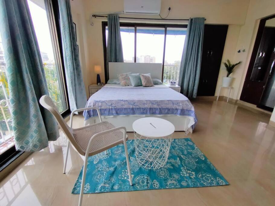- une chambre avec un lit, une table et des chaises dans l'établissement 7 - Studio Velankanni Heights, Behaind Nanavati Hospital, Vile Parle by Connekt Homes, à Mumbai