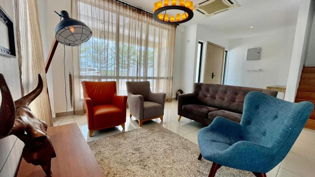 ein Wohnzimmer mit einem Sofa, Stühlen und einem Tisch in der Unterkunft Morib Homestay Near Gold Coast for Big Family and Golfer in Banting