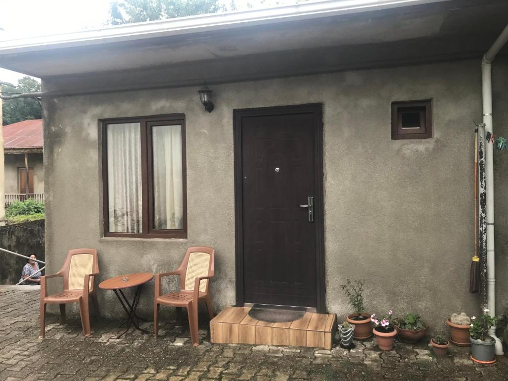une maison avec deux chaises, une table et une porte dans l'établissement gorda, à Koutaïssi