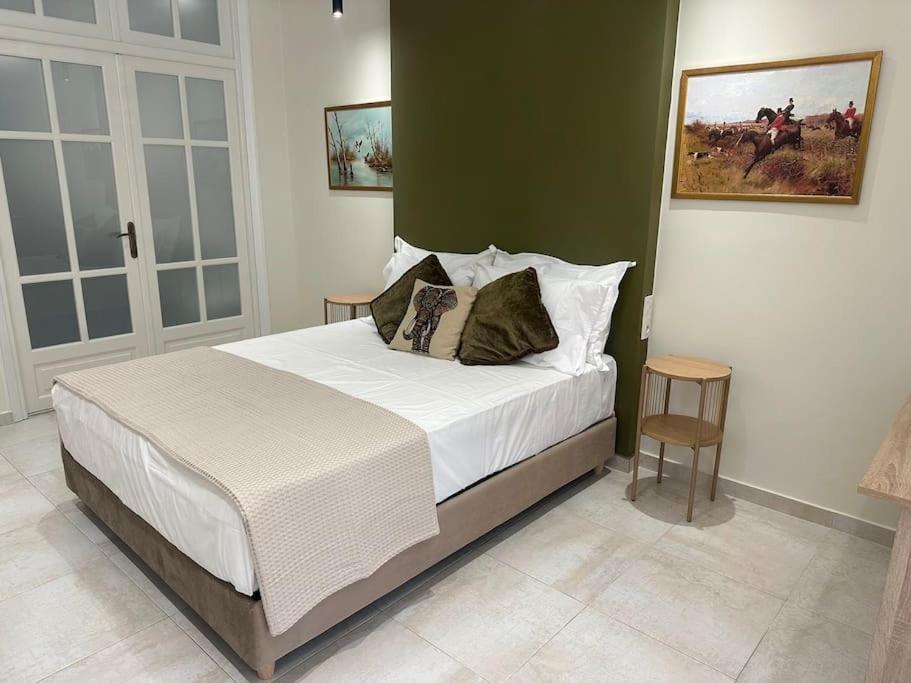 a bedroom with a bed with white sheets and pillows at Eclectic Apartment near Downtown in Heraklio