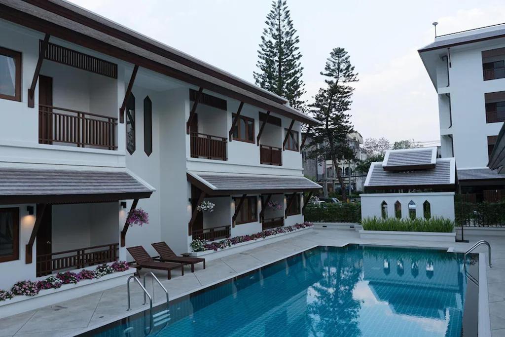 una casa con piscina al lado de un edificio en Villa Sanpakoi en Chiang Mai