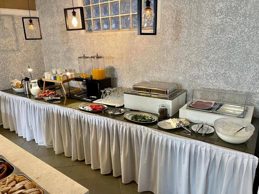 una mesa larga con comida en la cocina en Hotel Aulona, en Sarandë