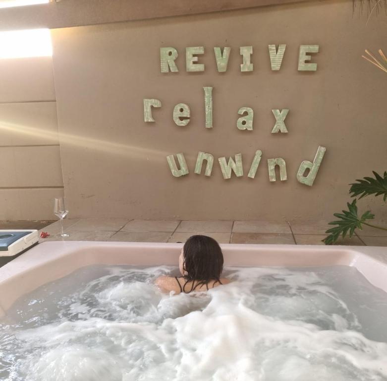a woman is sitting in a bath tub at Revive Self catering unit in Darling