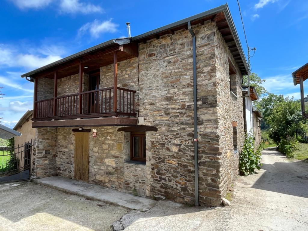 a brick house with a balcony on the side of it at La Casina de la Yeye San Cristóbal de Valdueza in San Cristóbal de Valdueza
