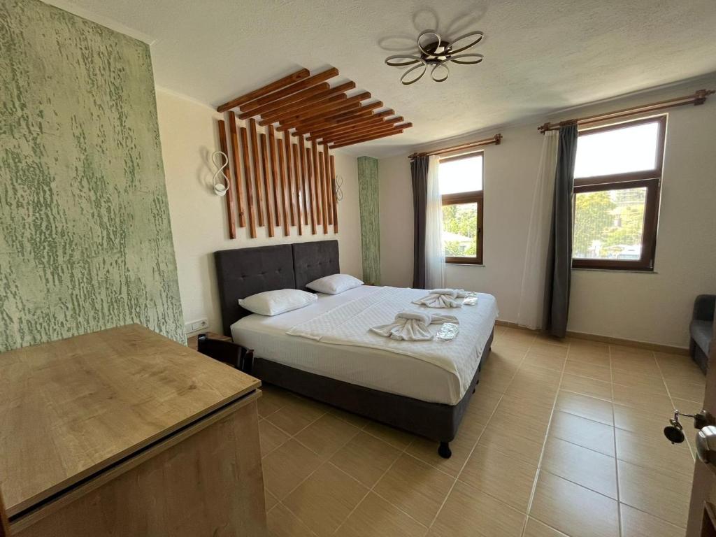a bedroom with a bed and a ceiling fan at Akar Butik Otel in Gokceada Town