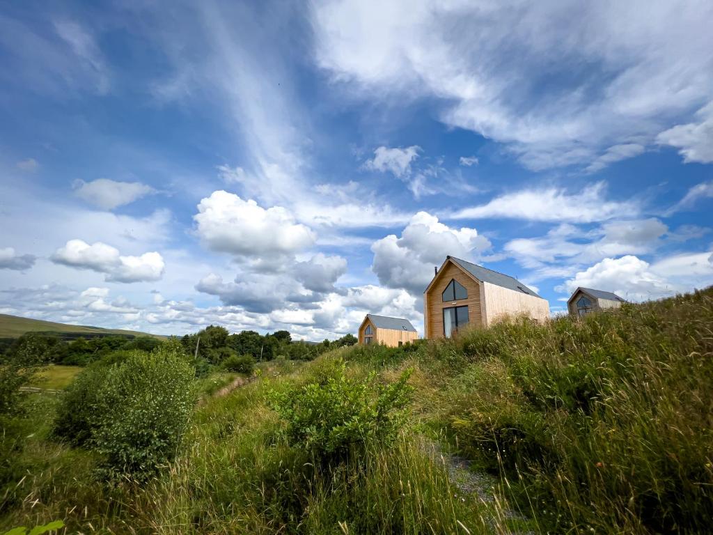 a house sitting on top of a grassy hill at Tarset Tor - Bothy Cabin 4 in Hexham