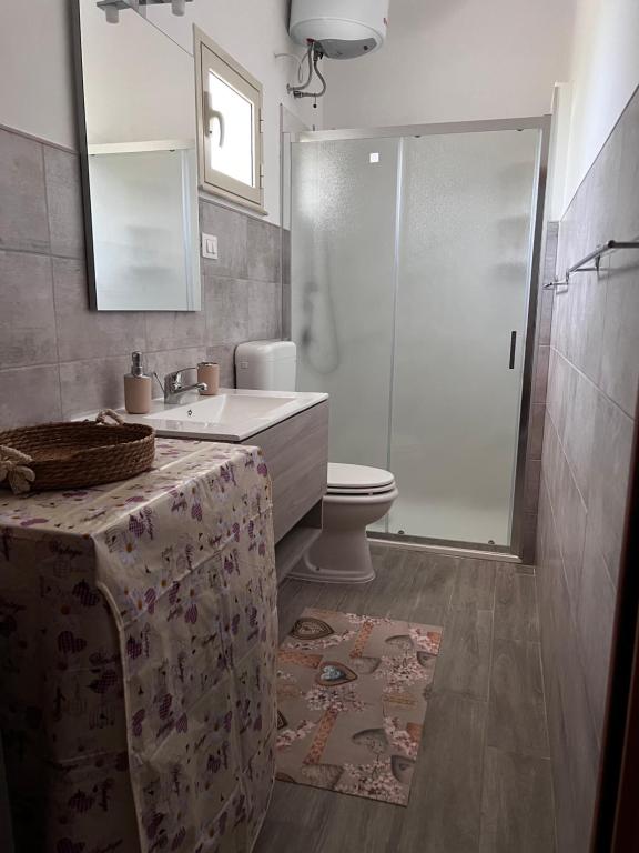 uma casa de banho com um chuveiro, um lavatório e um WC. em Casa I due Pini em Casa Modica