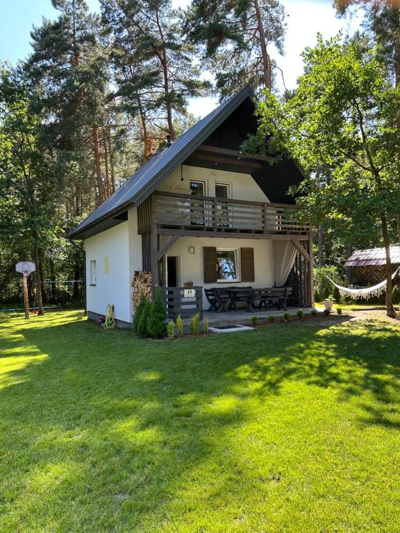 a house with a porch and a grass yard at Domek nad jeziorem - Białka in Białka
