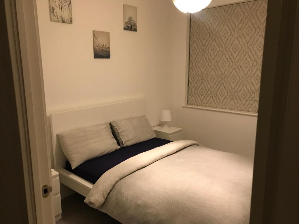 a small bedroom with a bed and a lamp at Private Room & Private Bathroom in Park Royal in London