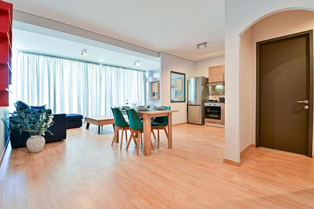 uma sala de estar com uma mesa e cadeiras verdes em Cozy apartment located on Piraeus Port area-(SPETS_D1) em Piraeus