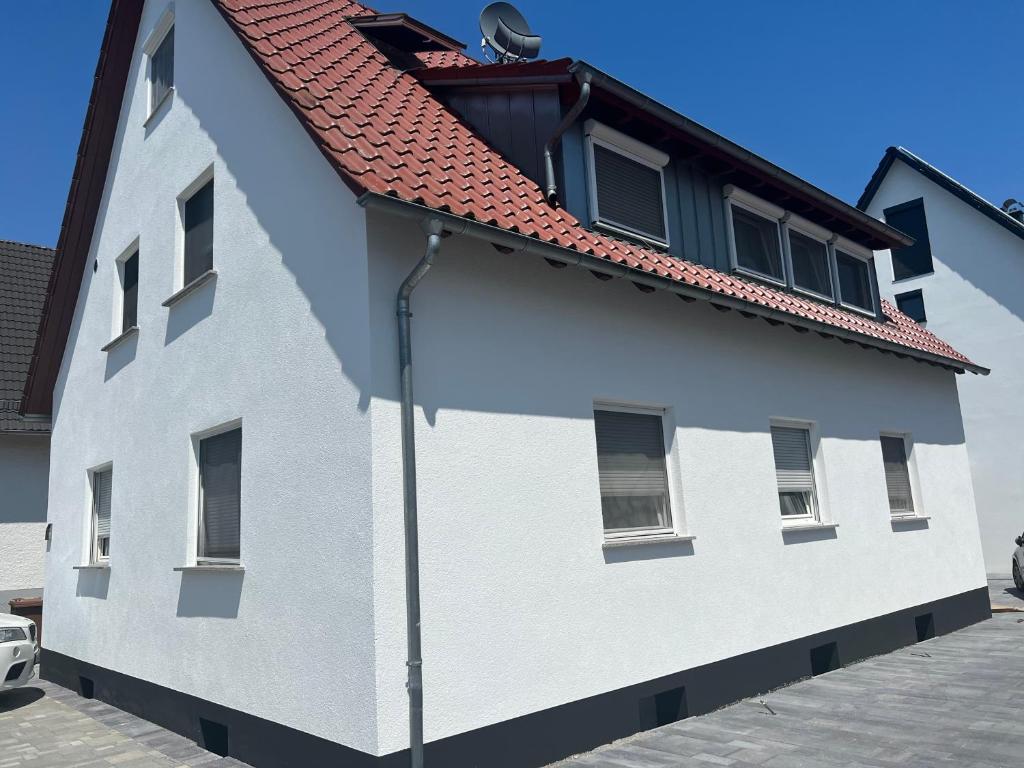 um edifício branco com um telhado vermelho em 4 Zimmer Ferienwohnung am Bodensee em Friedrichshafen