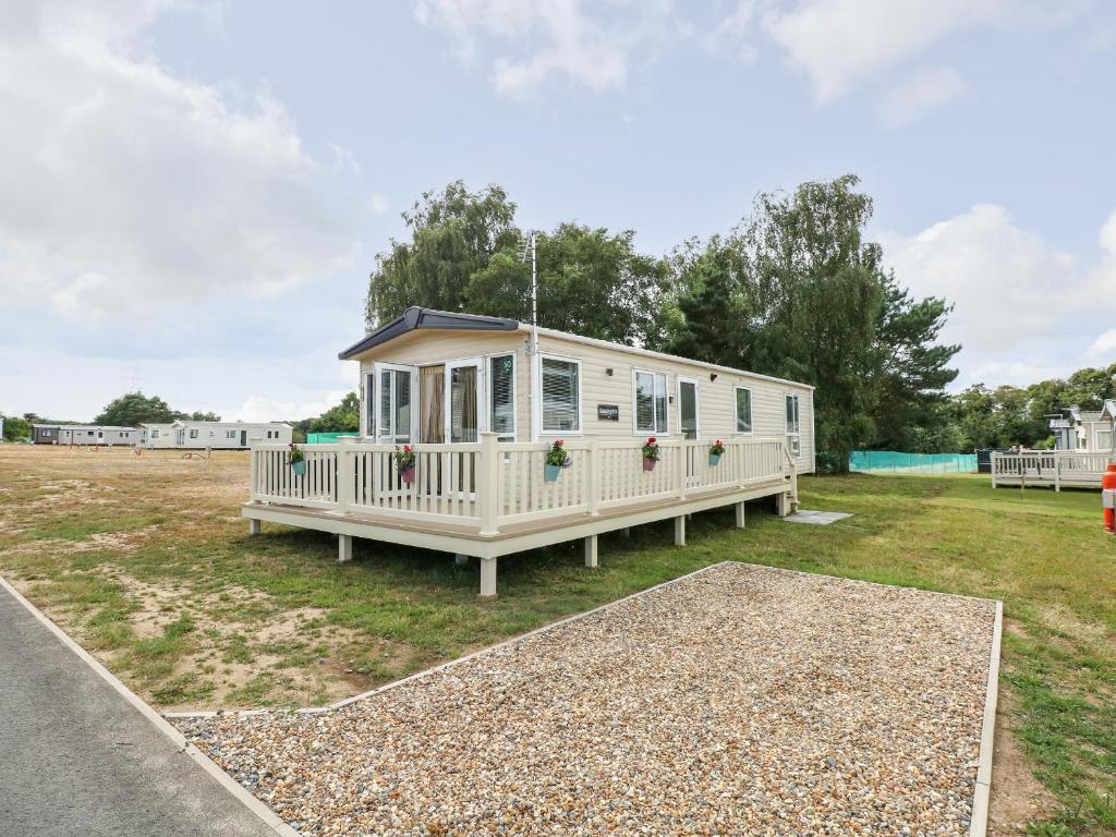 ein weißes Haus mit einer Veranda auf einem Hof in der Unterkunft 50, Foxburrow Hang in Great Yarmouth