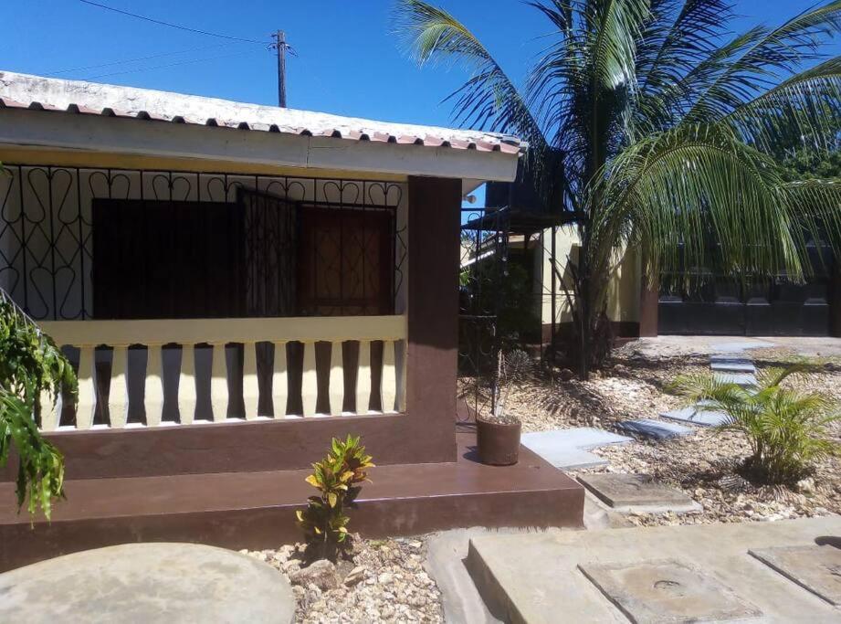 een klein huis met een hek ervoor bij Moringa Garden Cottage, mombasa, north coast, kikambala in Mtwapa