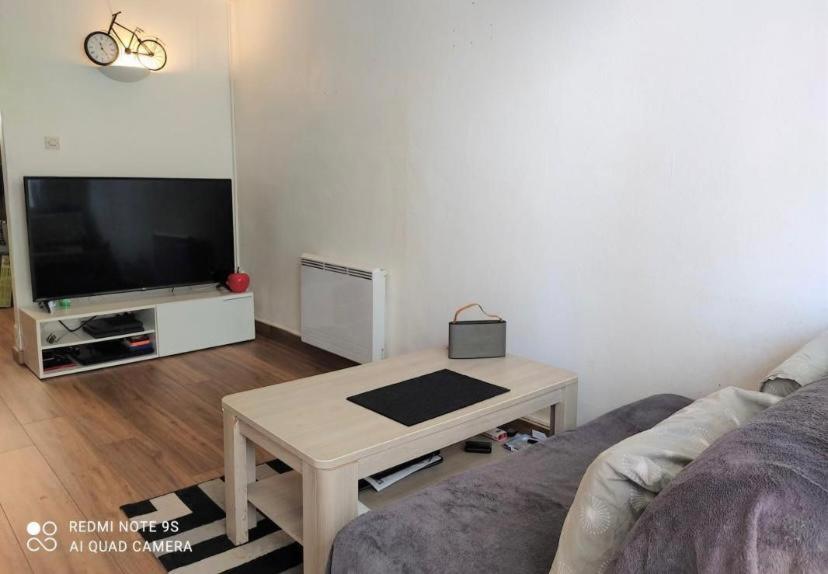 een woonkamer met een bank en een tafel bij Studio au Front de la Mer in Canet-en-Roussillon