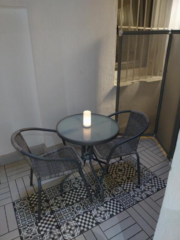 eine Kerze auf einem Tisch mit zwei Stühlen in der Unterkunft Céntrico apartamento con patio in Madrid