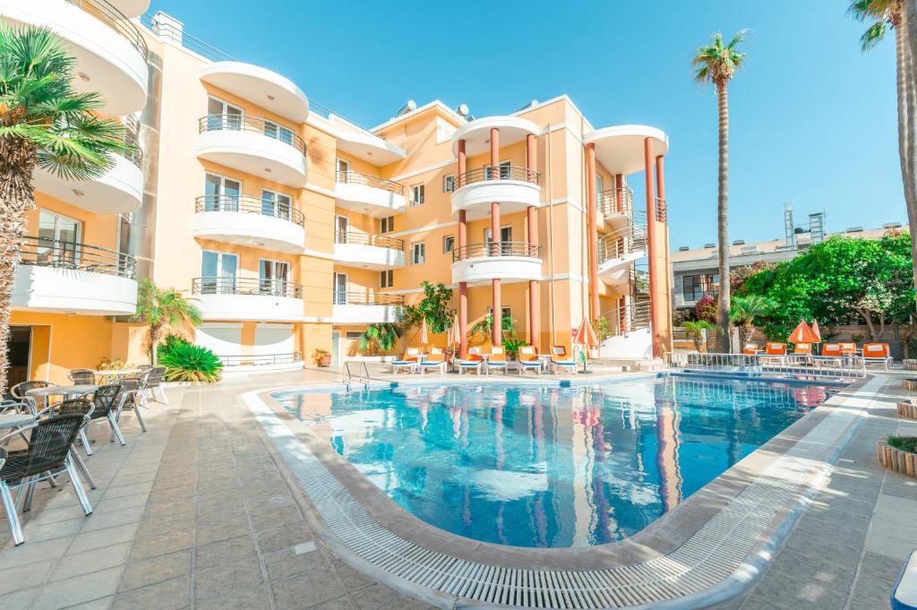 a swimming pool in front of a building at Kos City Apartments in Kos