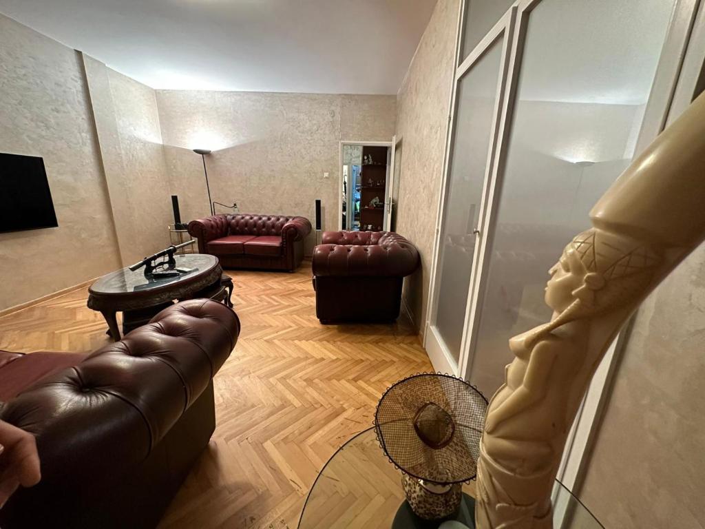 un soggiorno con divani in pelle e ventilatore di GBS Usce Apartments a Belgrado