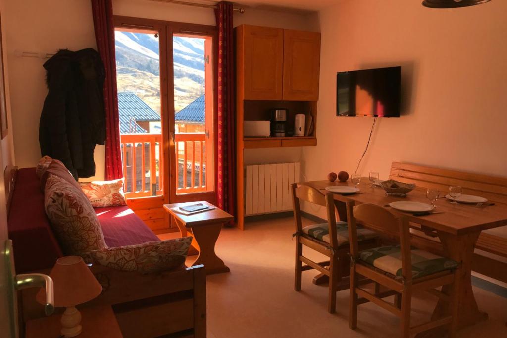 a living room with a table and a balcony at Les aiguilles d arves n 29 in Albiez-Montrond