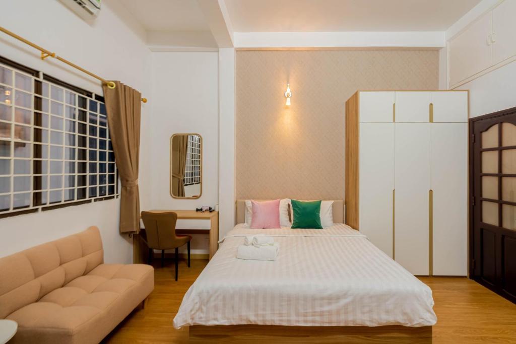 1 dormitorio con cama, sofá y mesa en Kansas Hotel & Apartment - Notre Dame en Ho Chi Minh