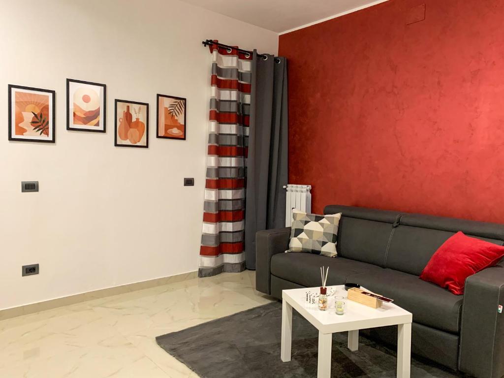 ein Wohnzimmer mit einem Sofa und einem Tisch in der Unterkunft Griseo - Sicily Holiday House in Misterbianco
