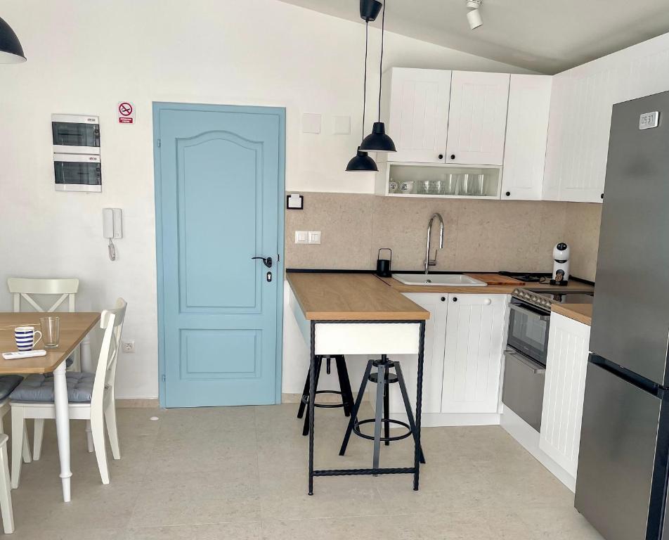 a kitchen with a blue door and a table at Riva House Tribunj in Tribunj