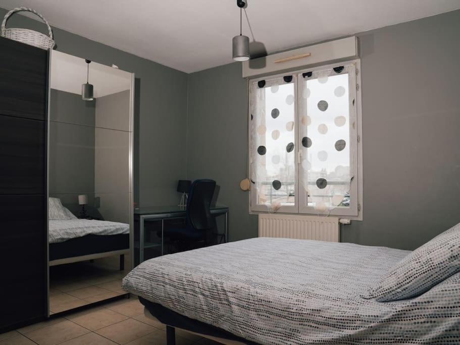 a bedroom with a bed and a window and a desk at La Plume argentée ONLY WOMEN femmes uniquement in Vénissieux