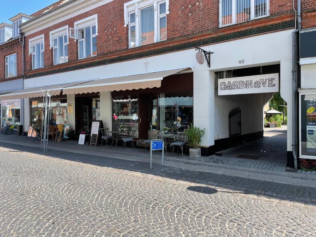 una tienda en una calle empedrada junto a un edificio en Sleep & Coffee Apartments, en Præstø