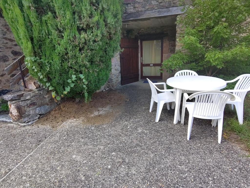 a white table and chairs in front of a building at Bienvenue en Transition 57 - La Levade in Najac