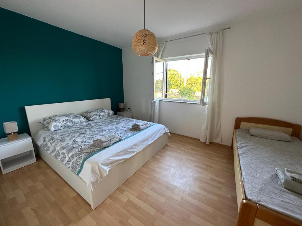 a bedroom with a large bed and a window at Relax and Unwind: Family-Friendly House near Zadar in Zagrad in Zadar