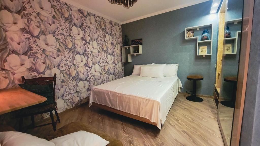 a bedroom with a bed and a wall with flowers at City Center Van Gogh Suite in Tbilisi City