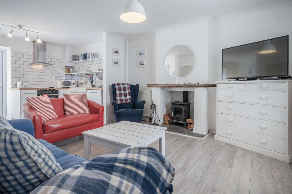 uma sala de estar com um sofá e uma mesa em Norton Cottage - 3 Bedroom Cottage - Tenby em Tenby