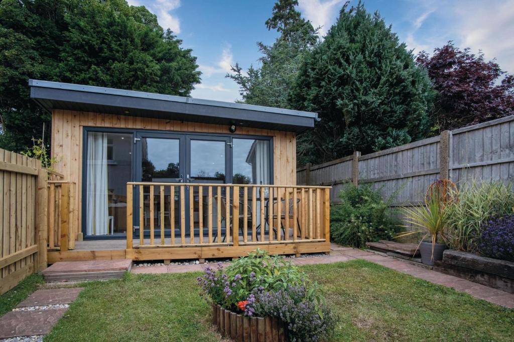 a tiny house in a garden with a fence at The Garden Lodge - 1 Bedroom Lodge - Tenby in Tenby