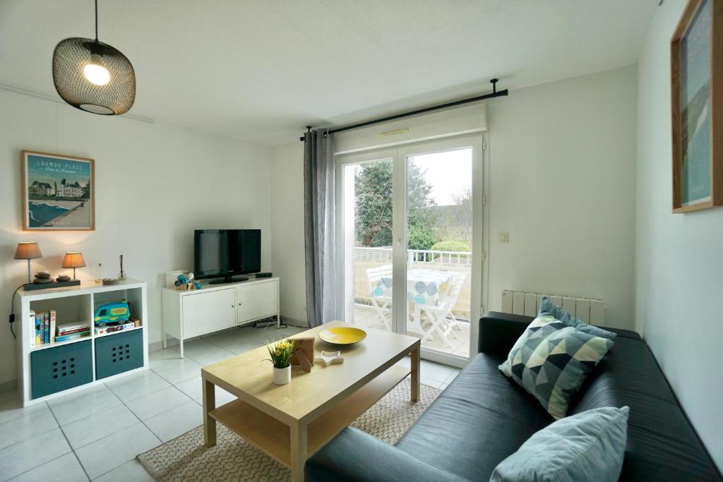 un salon avec un canapé bleu et une table dans l'établissement Duplex des 4 chemins, à Larmor-Plage