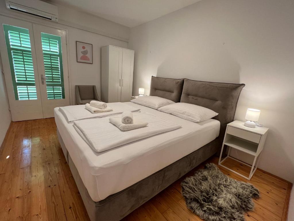 a bedroom with a large white bed with two towels on it at Villa Stina in Pisak