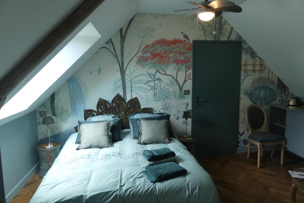 um quarto com uma cama branca e um mural de árvore em Le Clos Luly em Neulliac