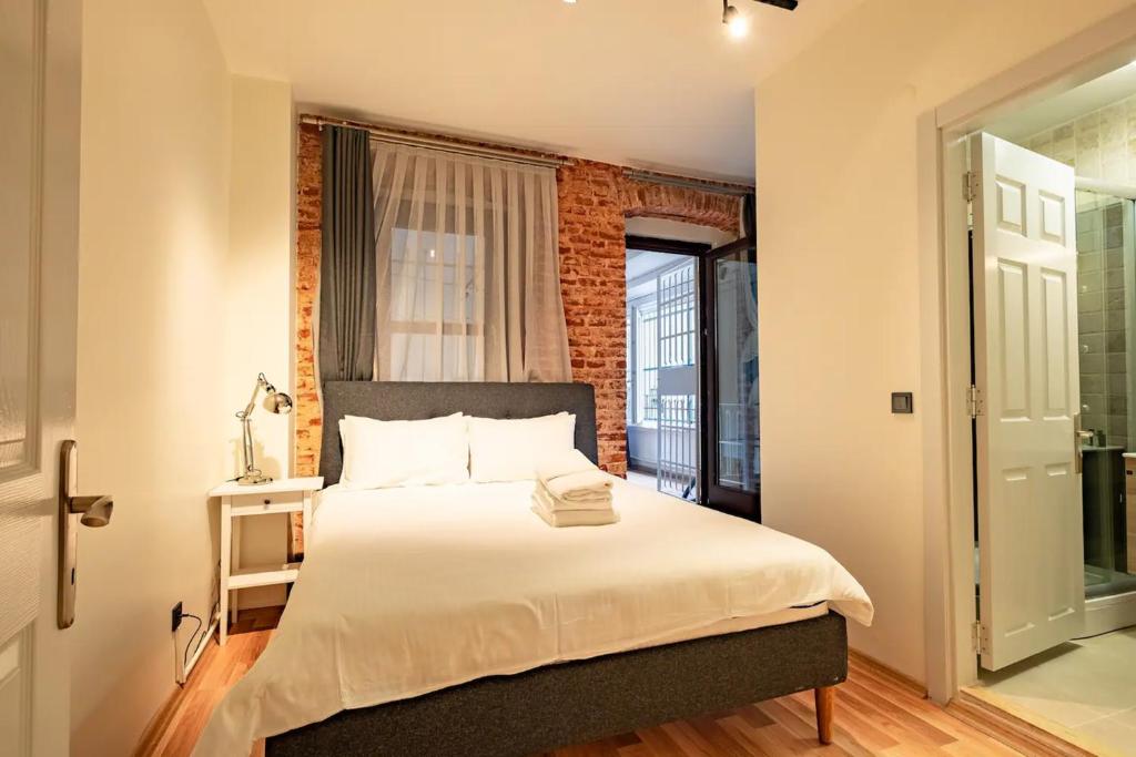 ein Schlafzimmer mit einem Bett mit Ziegelwand in der Unterkunft Homie Suites - Modern Apartments Nearby Istıklal Street & Galata Tower in Istanbul