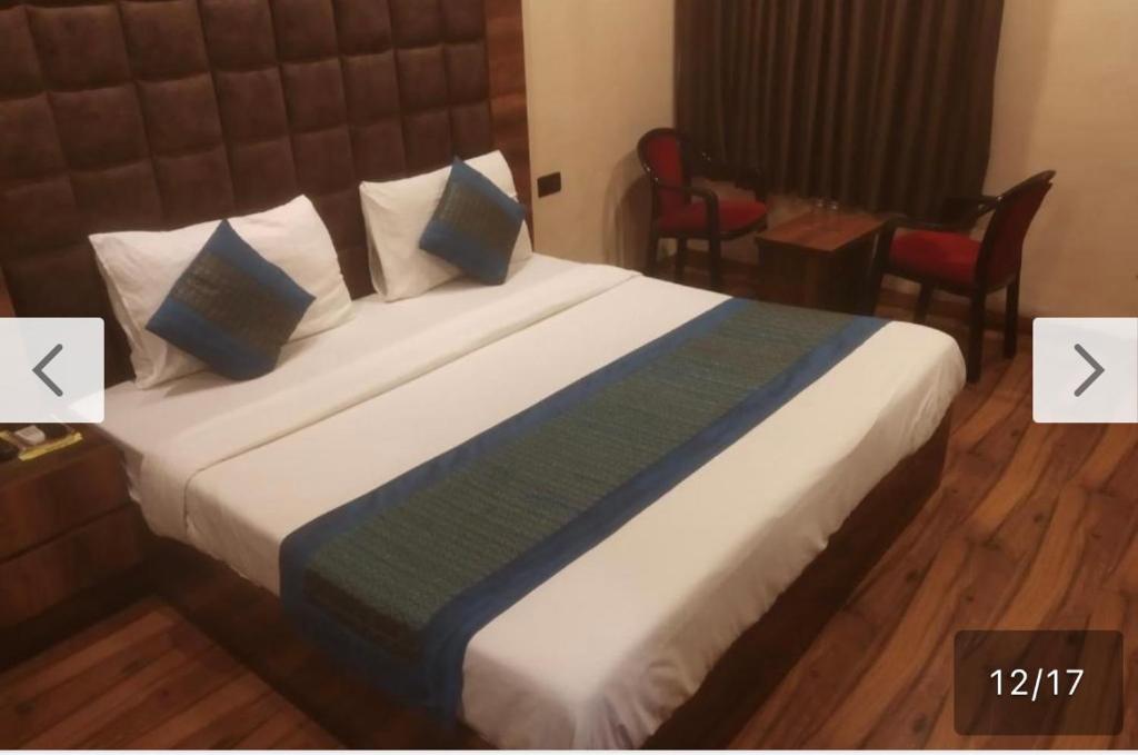 Habitación de hotel con cama grande con almohadas azules en Hotel Star Palace - Near Karol Bagh Metro, en Nueva Delhi