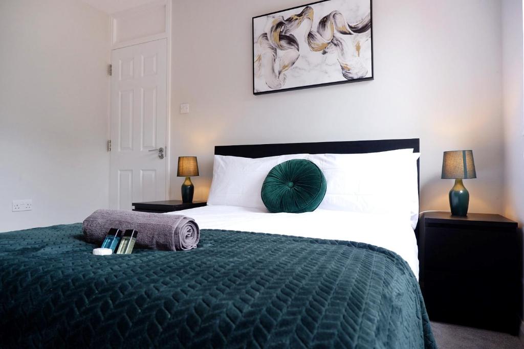 ein Schlafzimmer mit einem großen Bett und einer grünen Decke in der Unterkunft COMFORTABLE 4-Bed HOME WITH 3 BATHROOMS AND FREE PARKING! in Cambridge