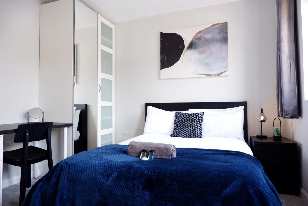 - une chambre avec un lit et une couverture bleue dans l'établissement COMFORTABLE 4-Bed HOME WITH 3 BATHROOMS AND FREE PARKING!, à Cambridge