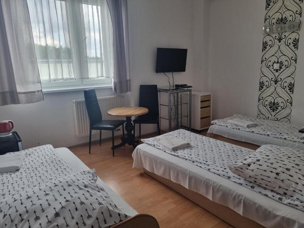 a room with two beds and a table and a chair at Nevada in Gdynia