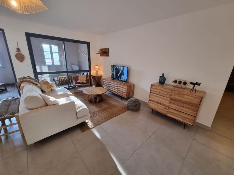 ein Wohnzimmer mit einem weißen Sofa und einem TV in der Unterkunft D34 - T3-Les Hauts du Port-parking-clim-wifi-50m du port in Bonifacio