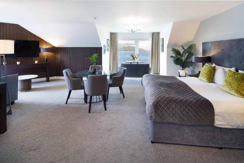 a hotel room with a bed and a dining room at The Cliff Hotel & Spa in Cardigan