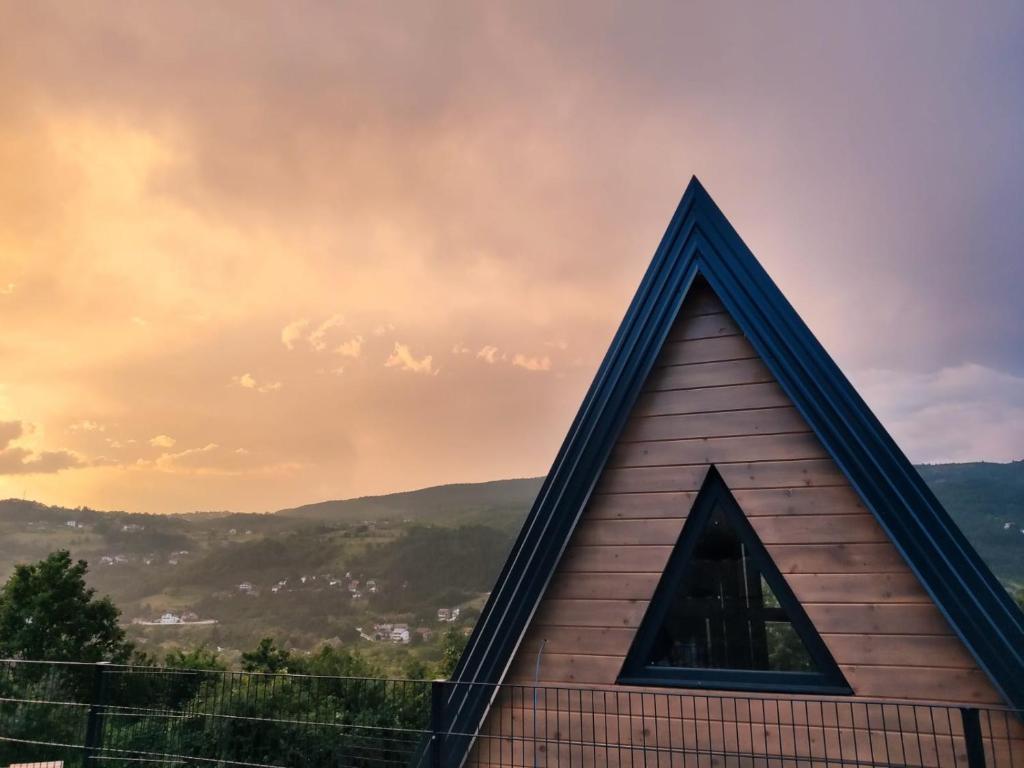 a pyramid shaped building with a sunset in the background at Stone Chalets - TERRA in Jajce