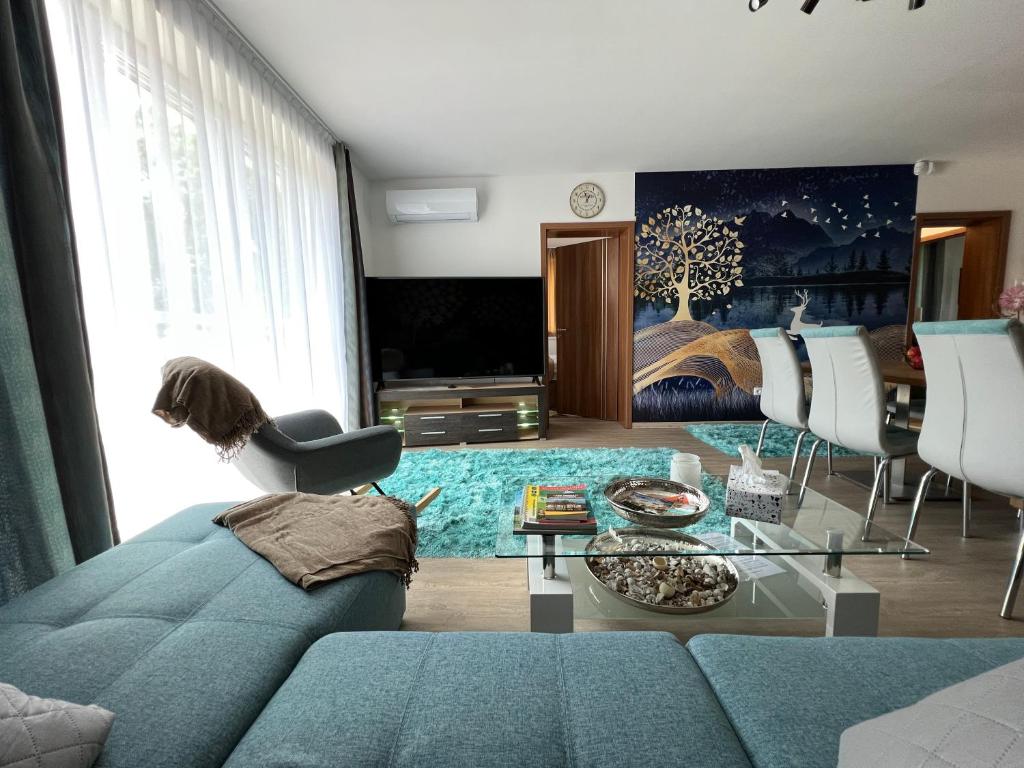 sala de estar con sofá azul y TV en Jázmin Apartman en Sárvár